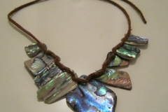 Made of New Zealand Abalone shells, linked by a leather chain.